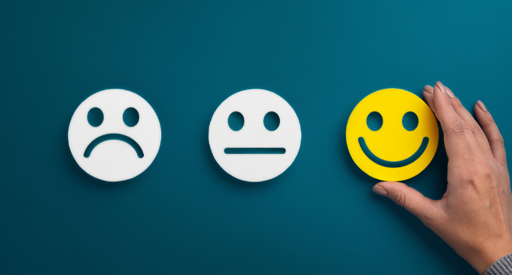 Three different cut outs of smiley faces with different expressions